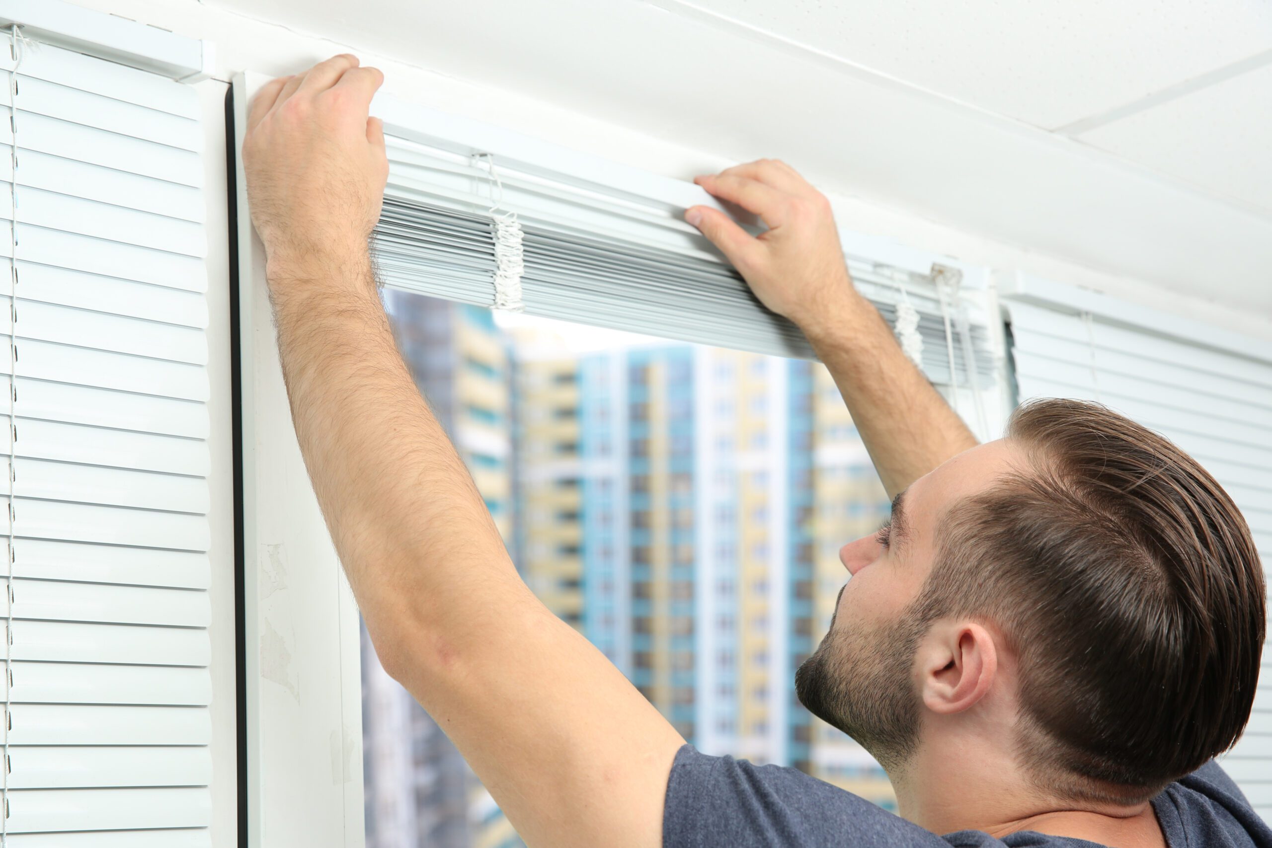 Man Installing Window Blinds at Home
